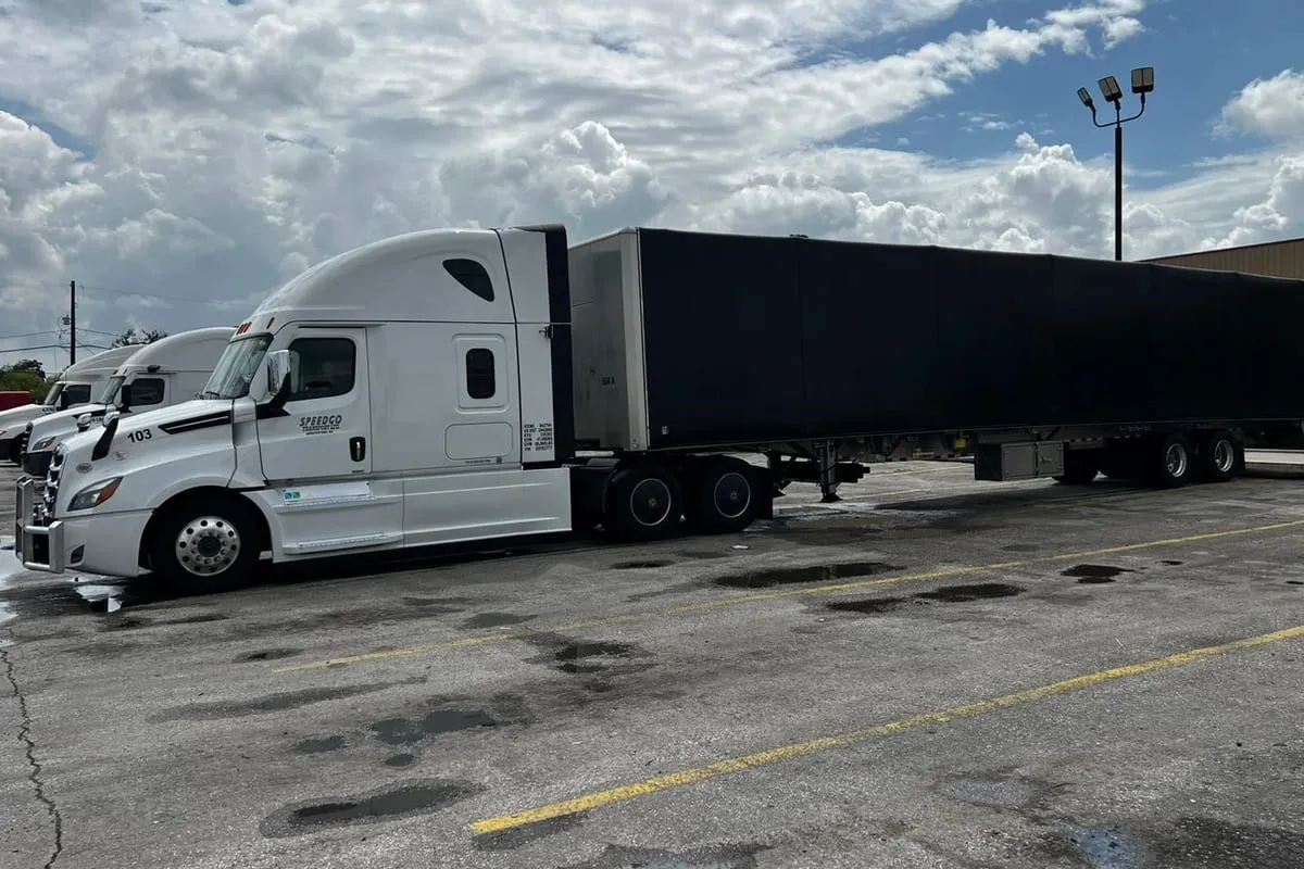 White Speedgo Transport truck pulling a covered trailer for consolidated LTL freight