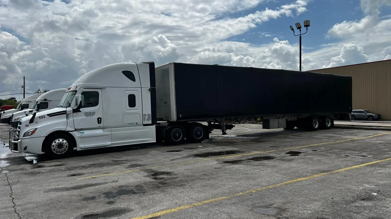 White Speedgo Transport truck pulling a covered trailer for consolidated LTL freight