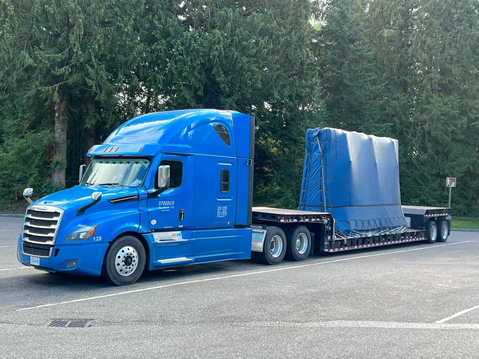 Blue Speedgo Transport truck with a tarped load on a 44' double drop trailer